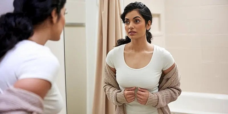 Woman looking at reflection in mirror.