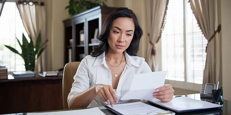 Woman reviewing documents in a professional setting.
