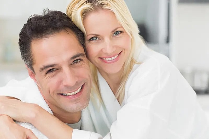 Happy couple smiling together in bathrobes.