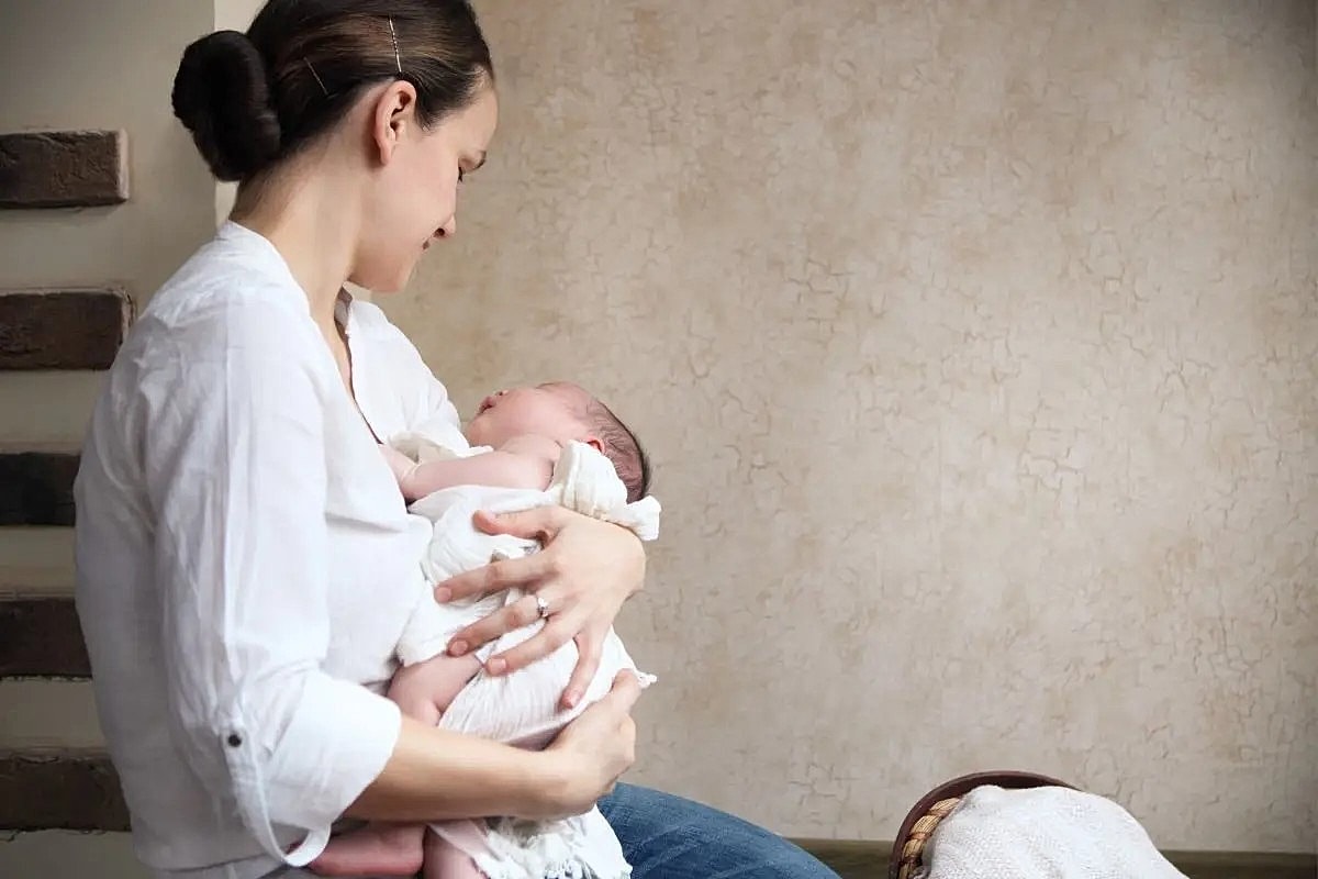 Mother holding her newborn baby lovingly.