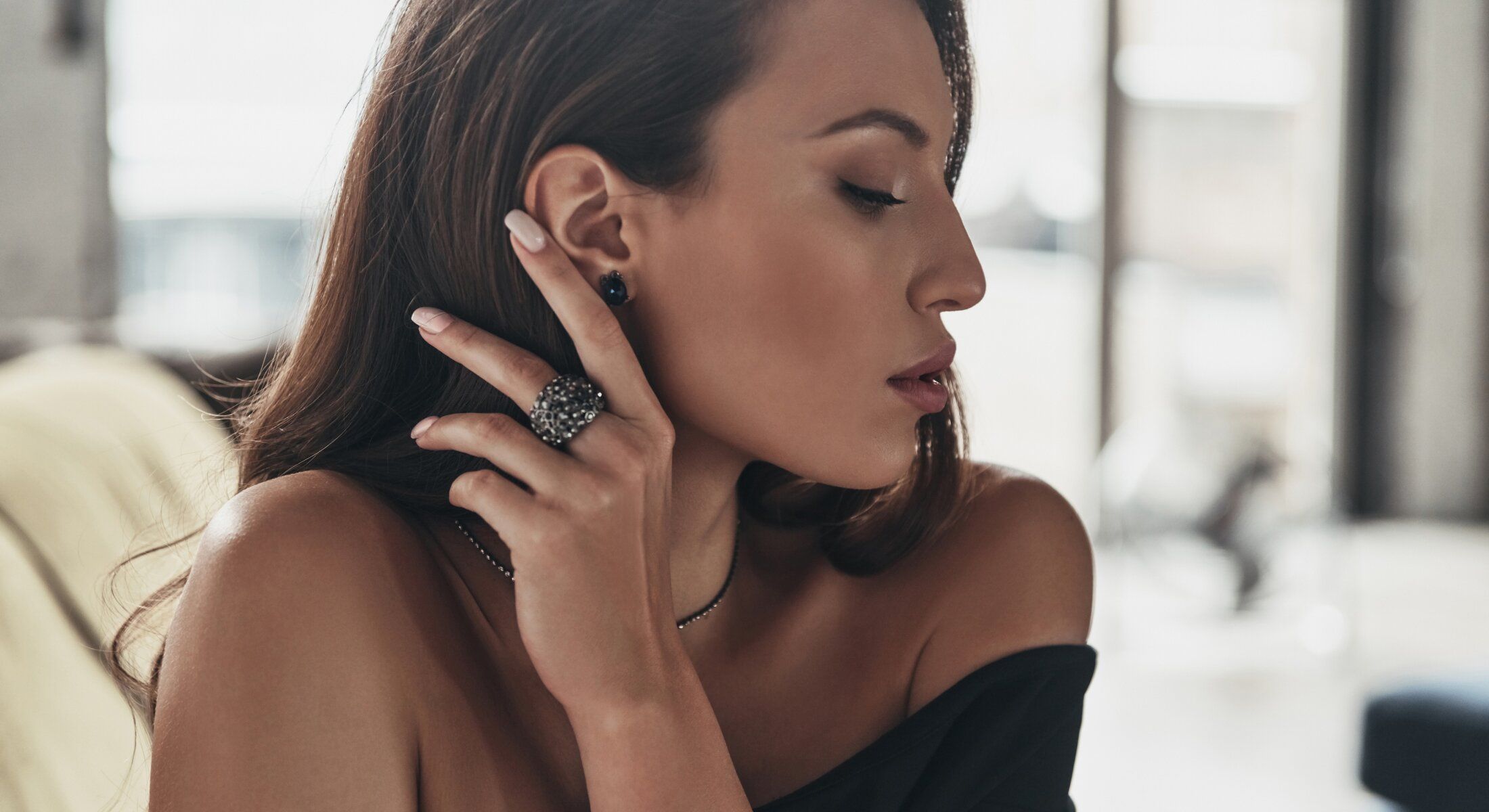 Woman showcasing elegant jewelry in natural light.