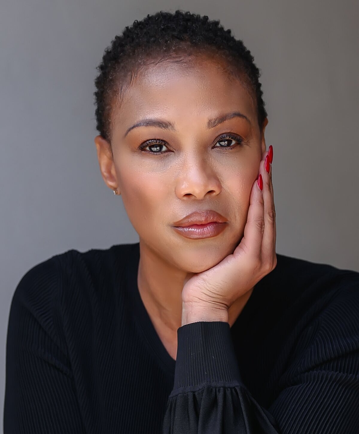 Woman with short hair resting her face.