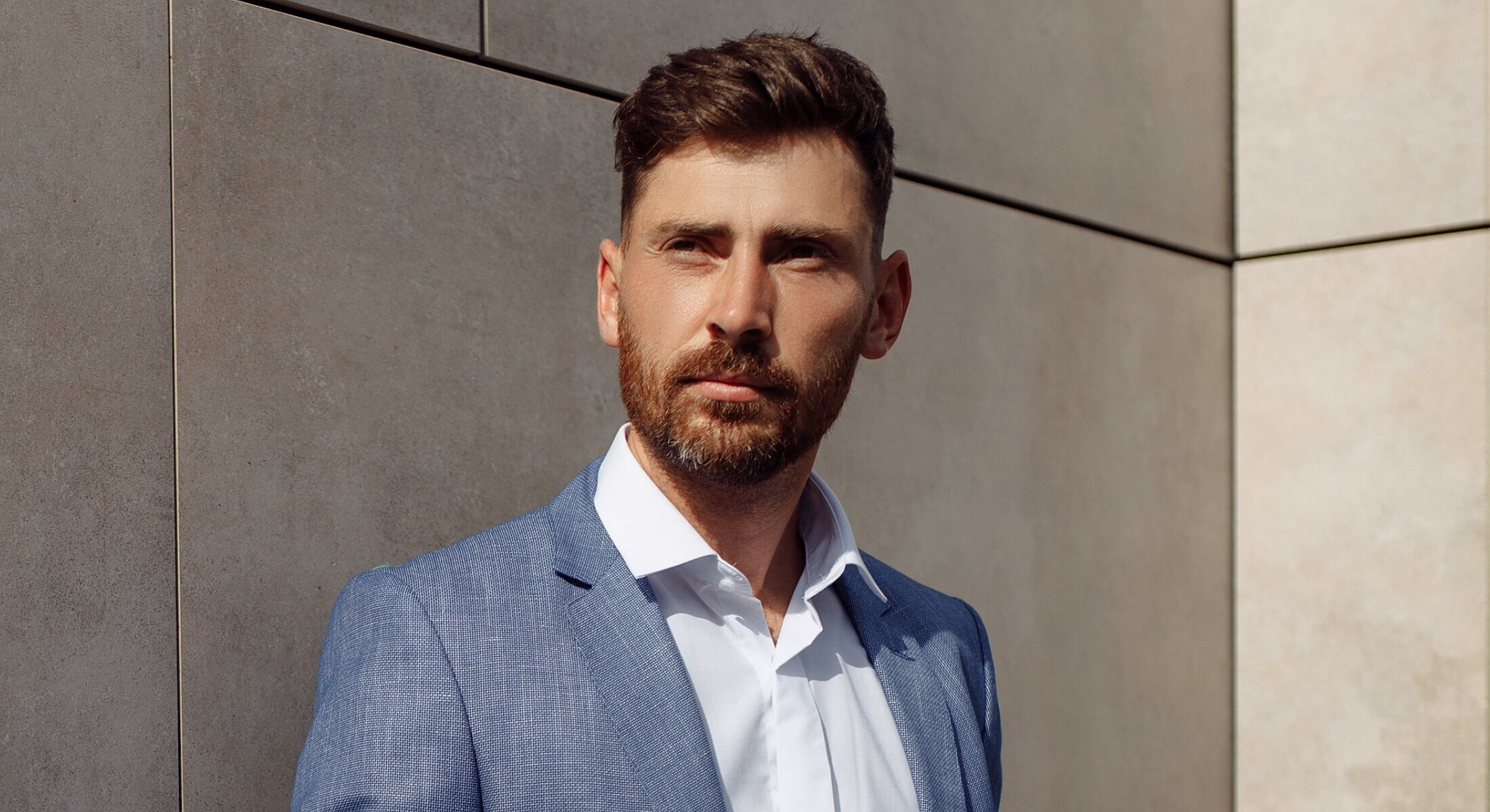 Man in suit against a modern background.