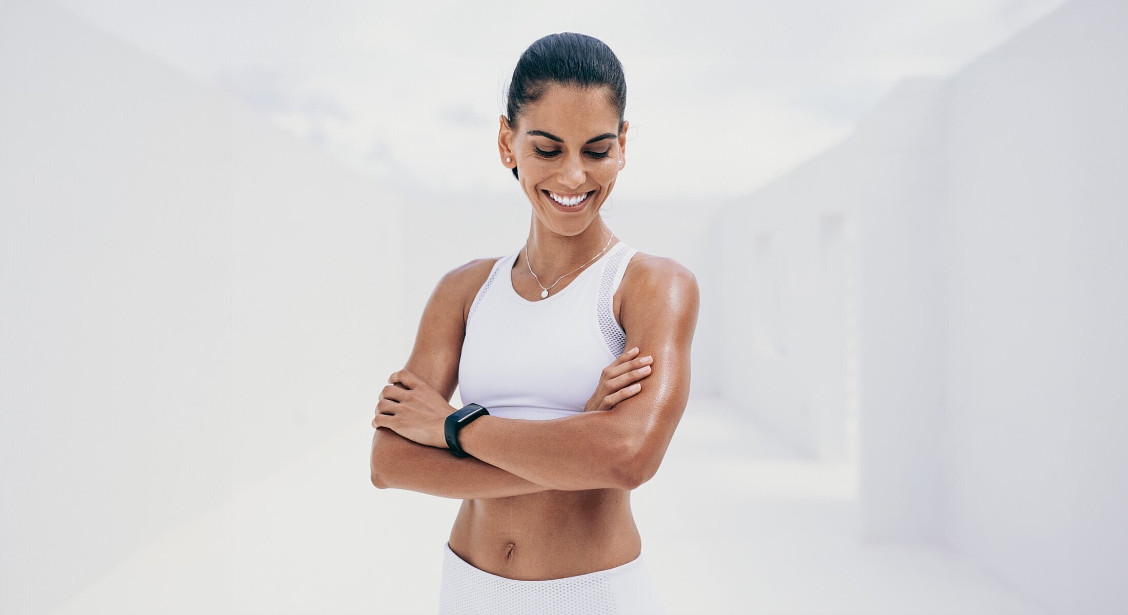 Smiling woman in athletic wear with smartwatch.
