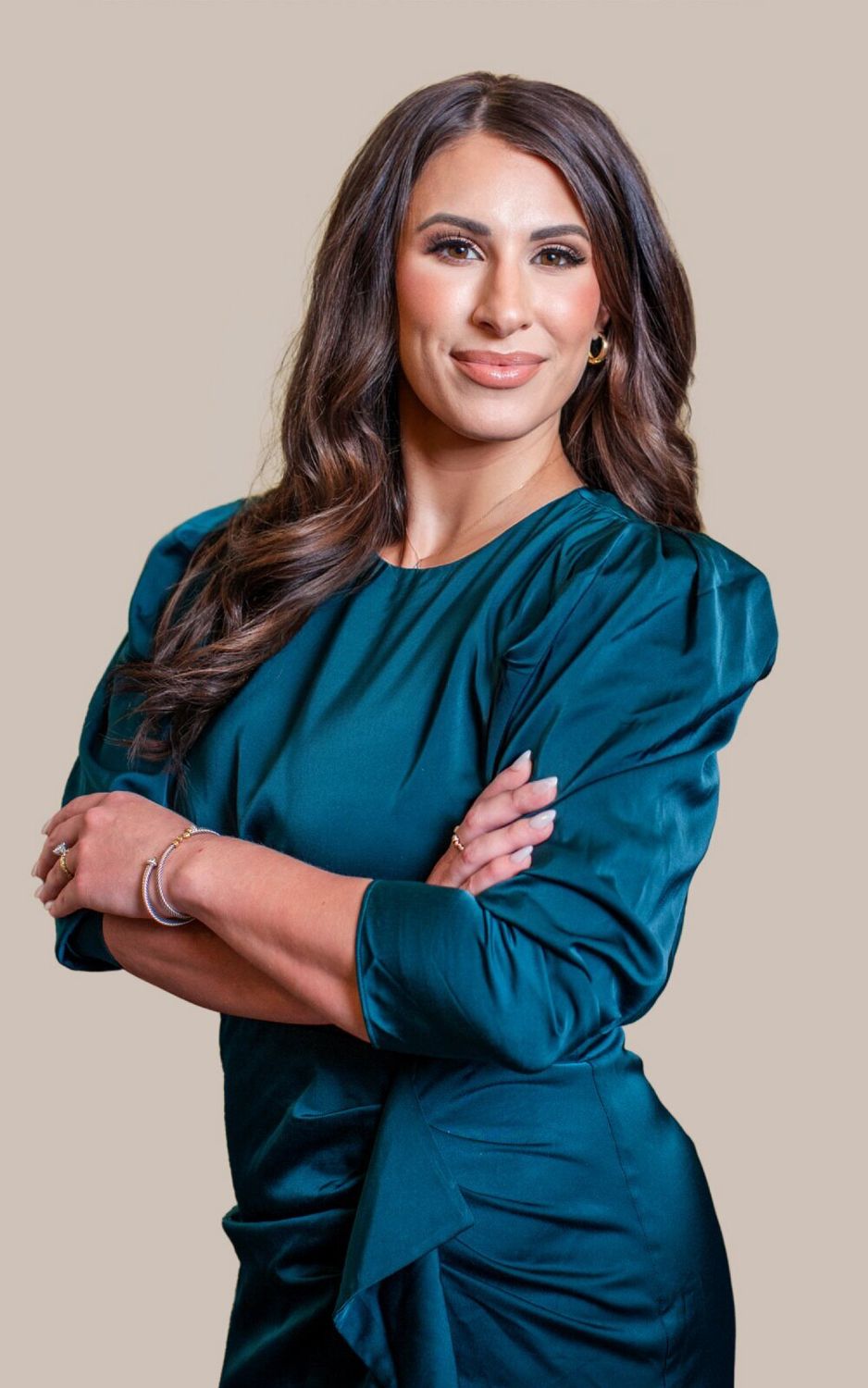Professional woman in teal dress, arms crossed.