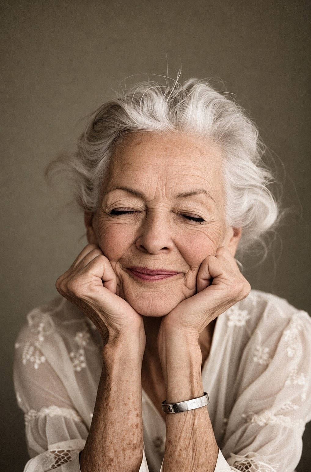 Colorized portrait of a mature woman smiling gently with her eyes closed and her face resting in her hands.