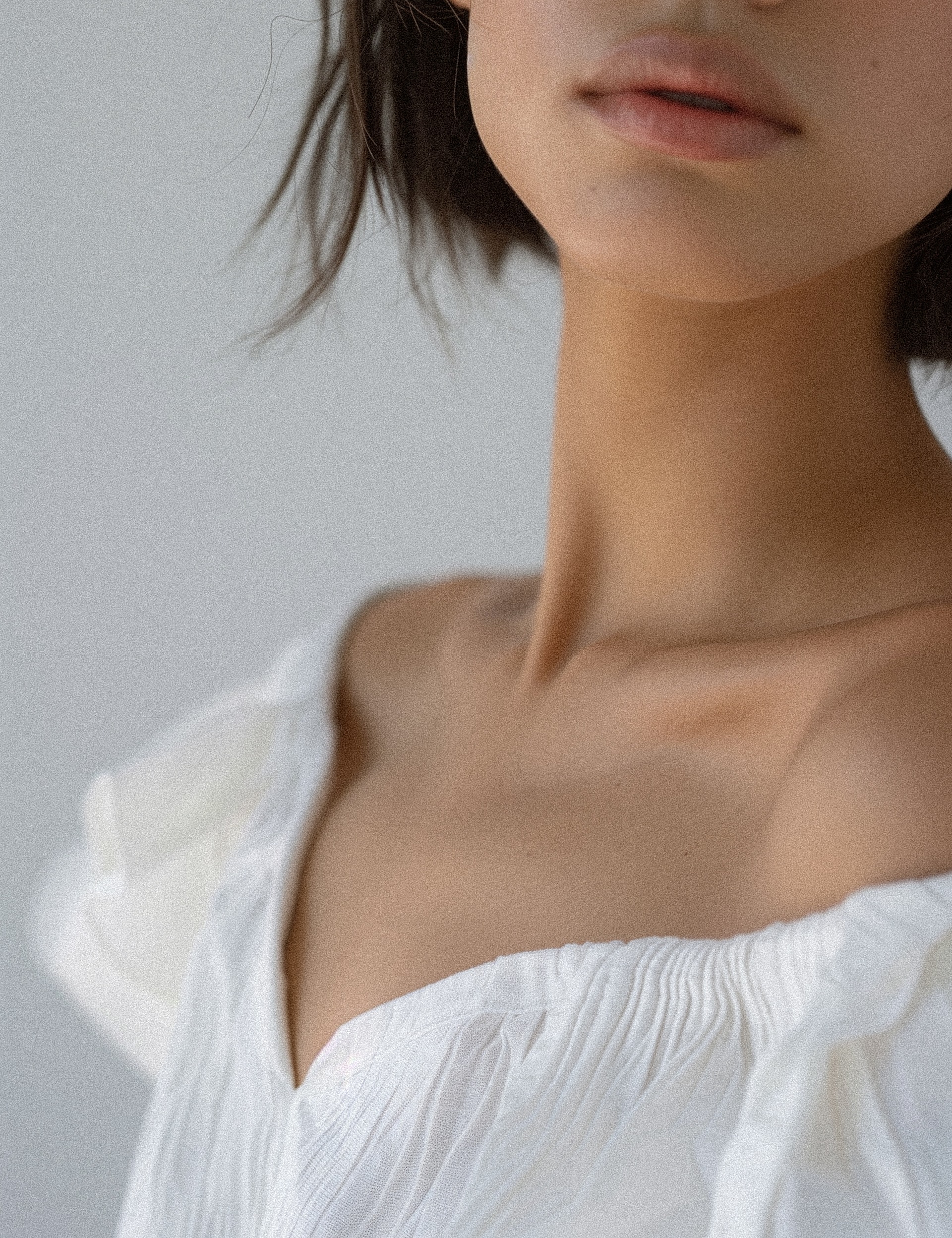 Close-up of shoulder and lips in soft lighting