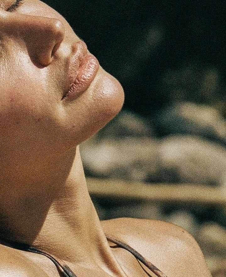 Sunlight across a neck and shoulder against a softly shaded outdoor background