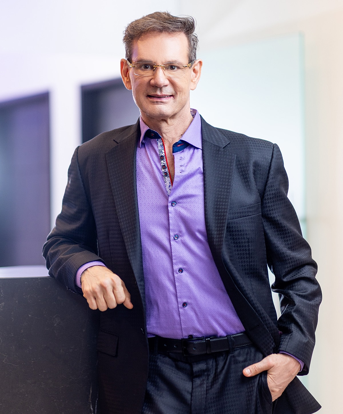 Plastic surgeon in operating room setting, smiling.