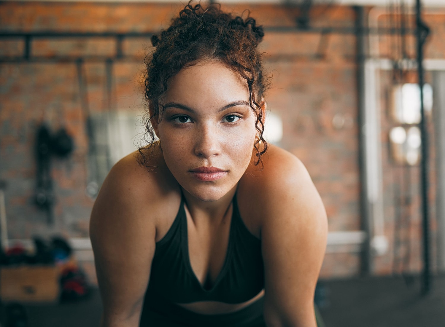 Woman in athletic wear at a gym, illustrating considerations when choosing between breast reduction and breast lift surgery.