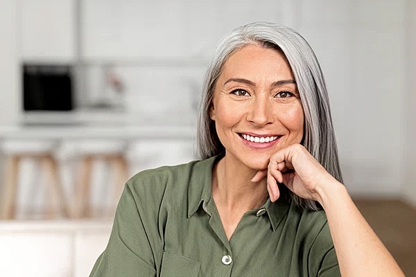 charming mature asian lady looking at camera and smiles 0