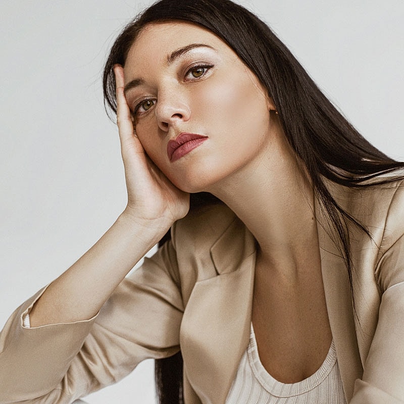 Woman in a blazer with thoughtful expression.