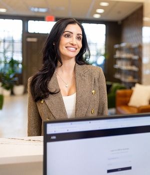 Smiling woman at a reception desk.