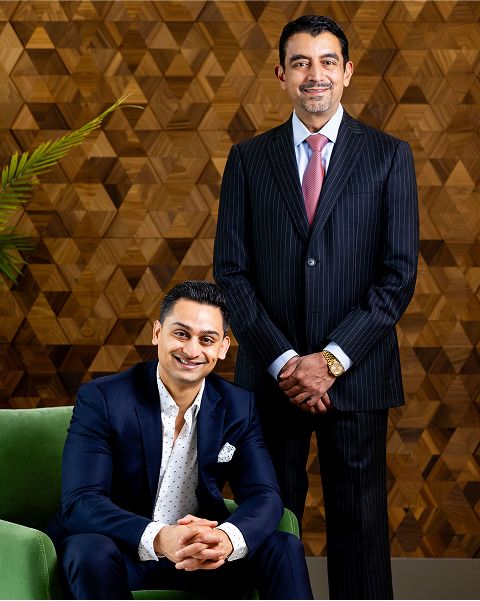 Two men posing in smart business attire.