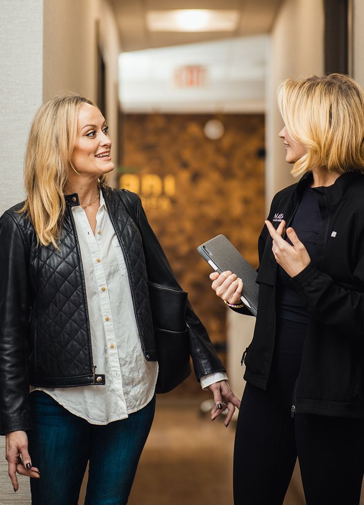 Two women chatting in a hallway.