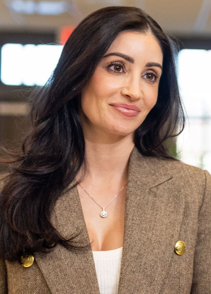Woman in blazer smiling at an event.