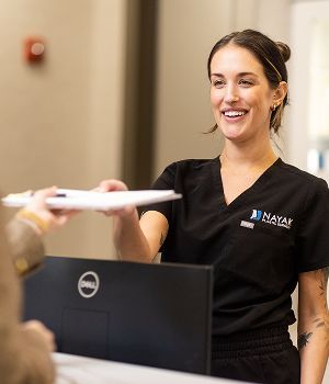 Receptionist handing documents to a client.
