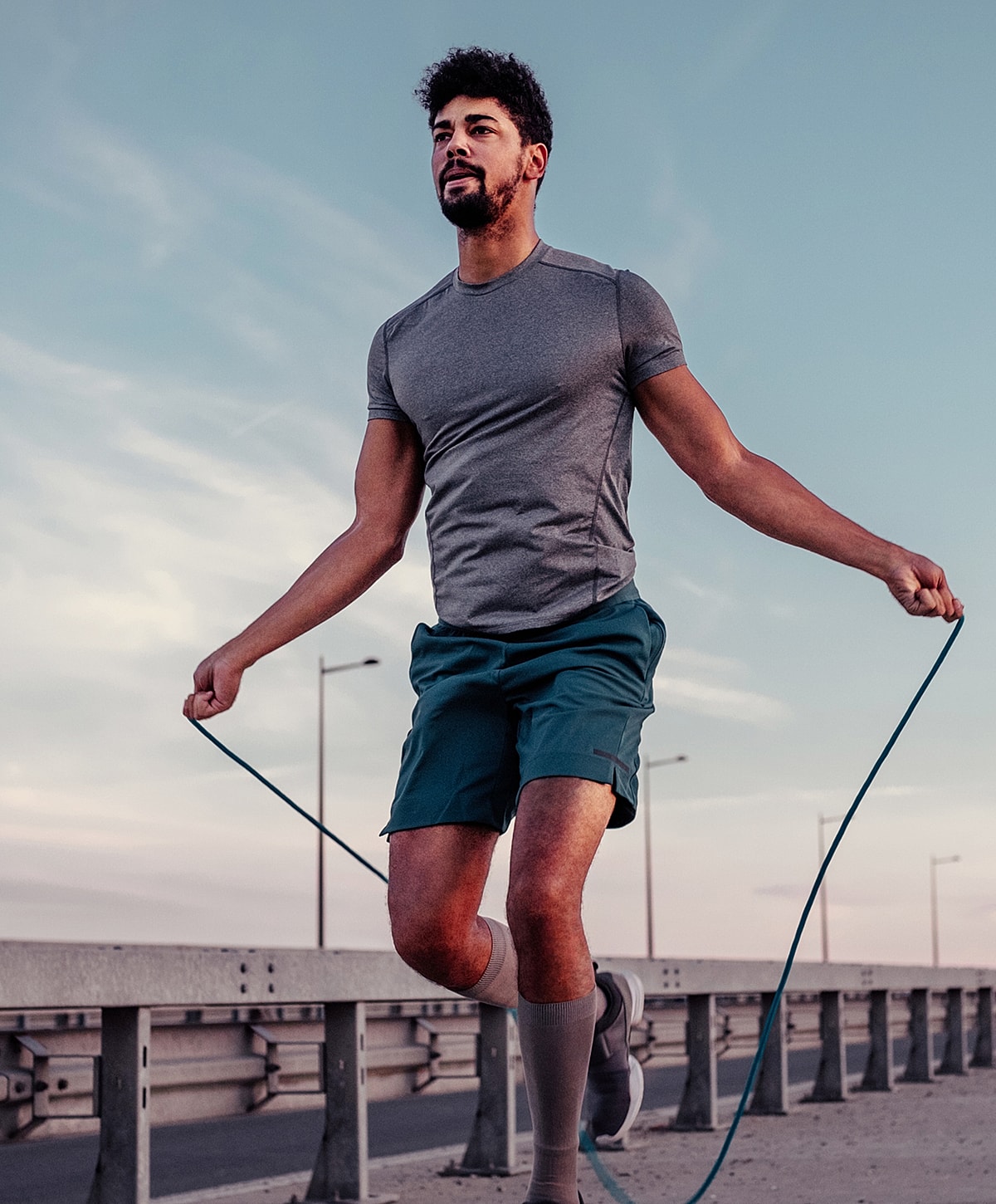 sciatica treatment patient model jumping rope outdoors at sunset.