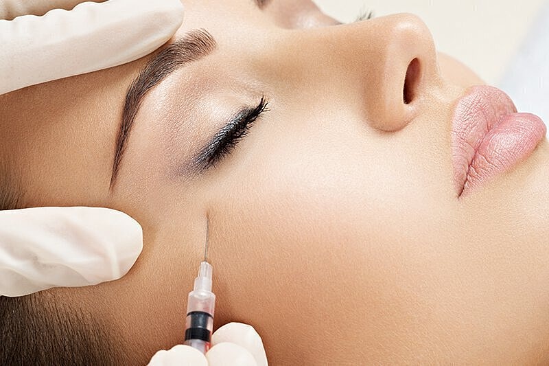Woman's face, recieving injection for botox.