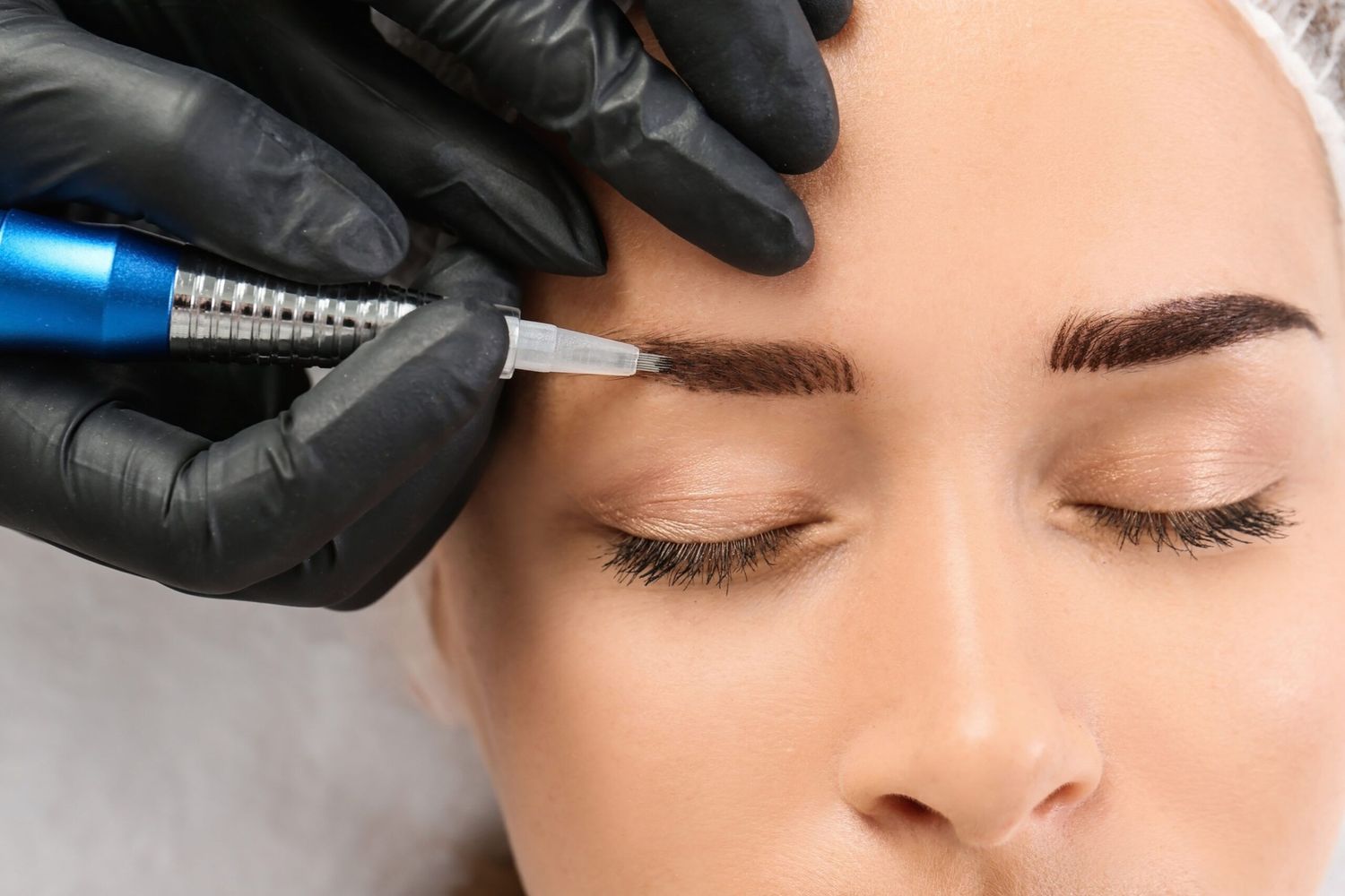 A woman getting her eyebrows tattooed.