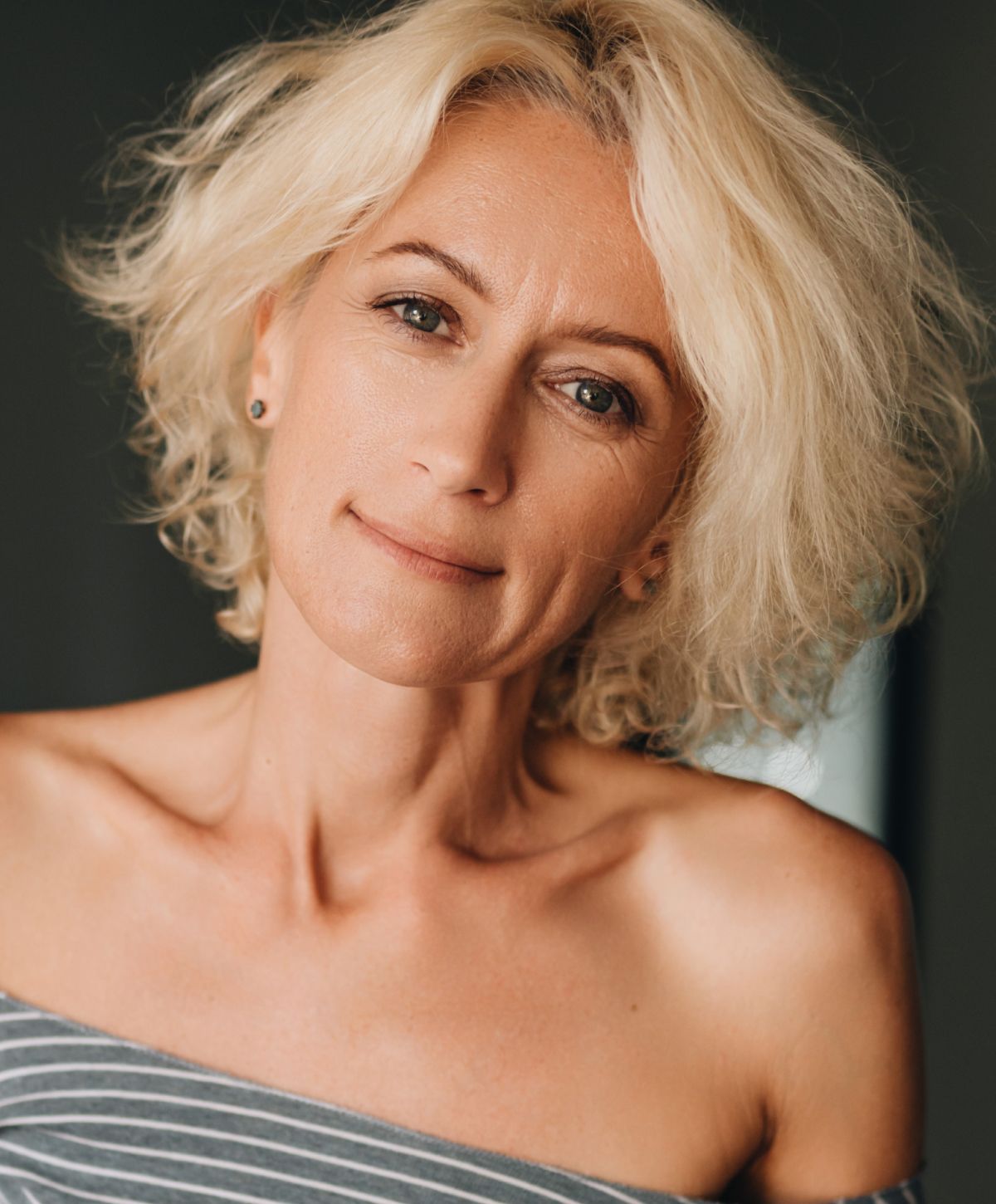 Smiling woman with curly blonde hair.