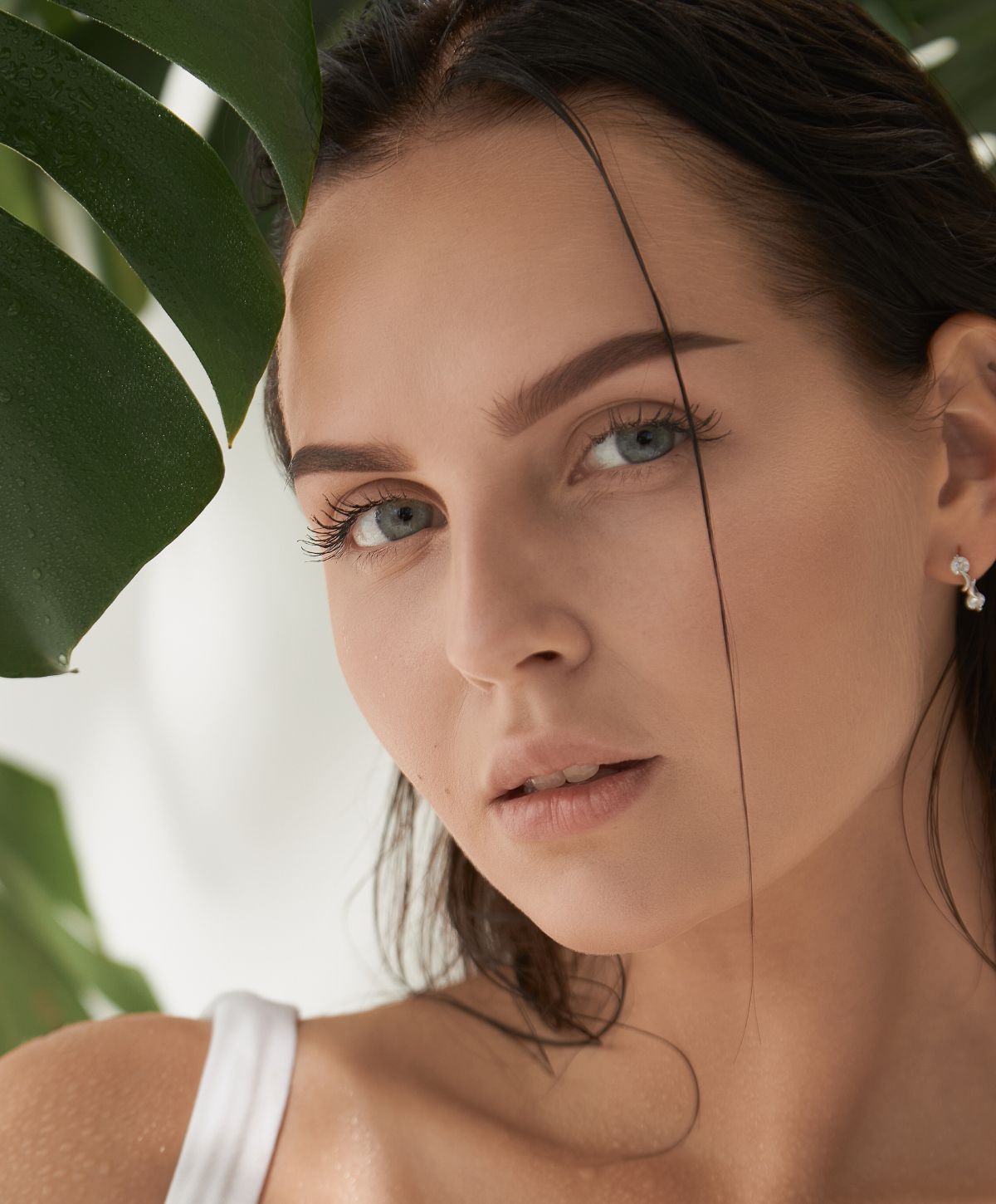 Close-up of a woman with foliage background.