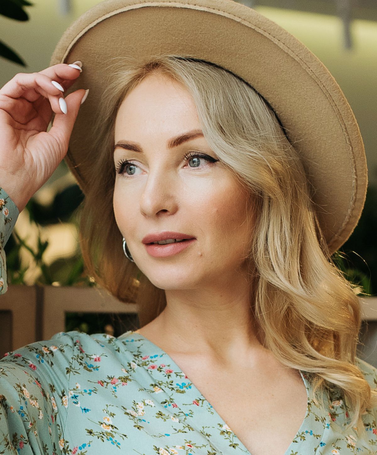 Woman in floral dress with a hat.
