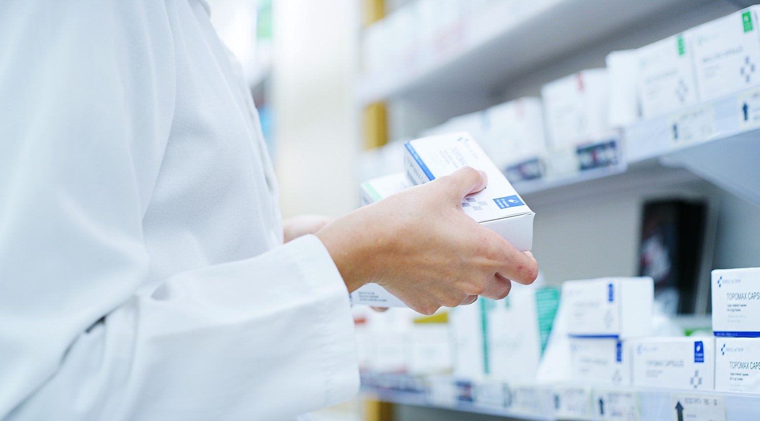 Pharmacist examining medication in pharmacy.