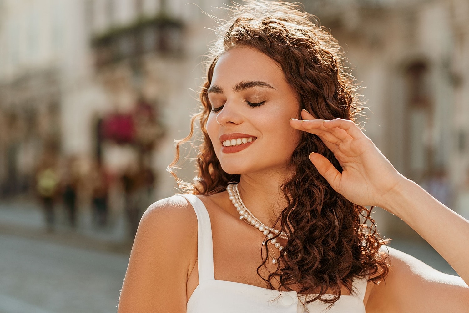 Woman with smooth glowing skin smiling in sunlight, representing natural-looking results from Botox and dermal fillers treatments