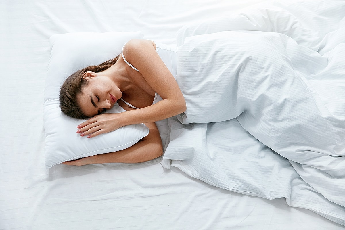 Woman peacefully sleeping on a bed.