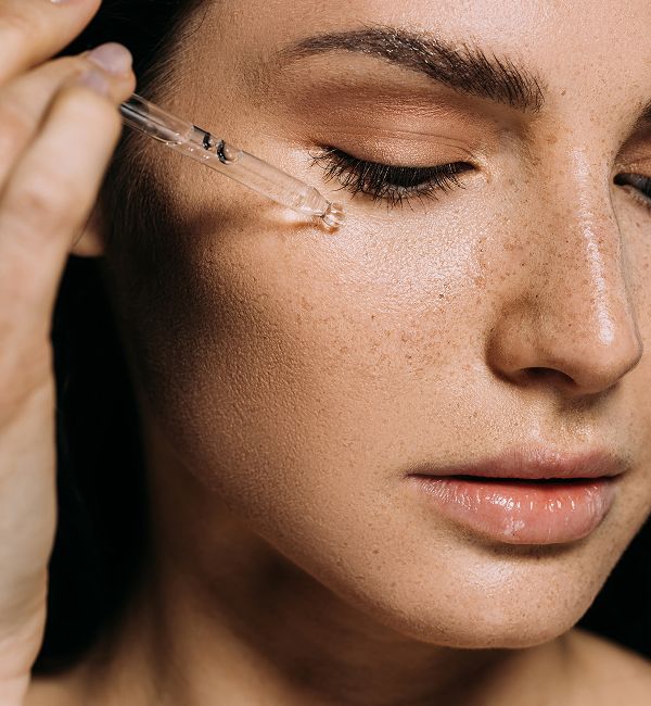Applying serum to a woman's face.