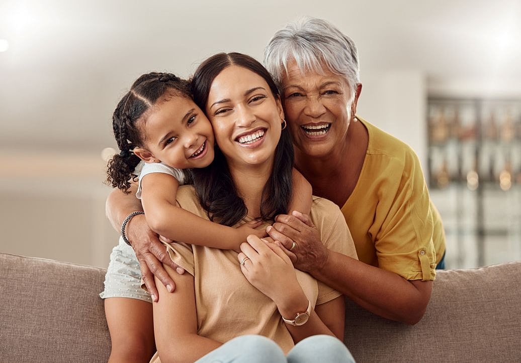 Smiling multigenerational family at home, representing women exploring mommy makeover trends in Tampa.