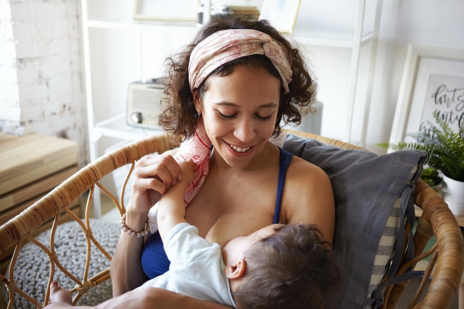 breast implant patient model breastfeeding her child on a couch