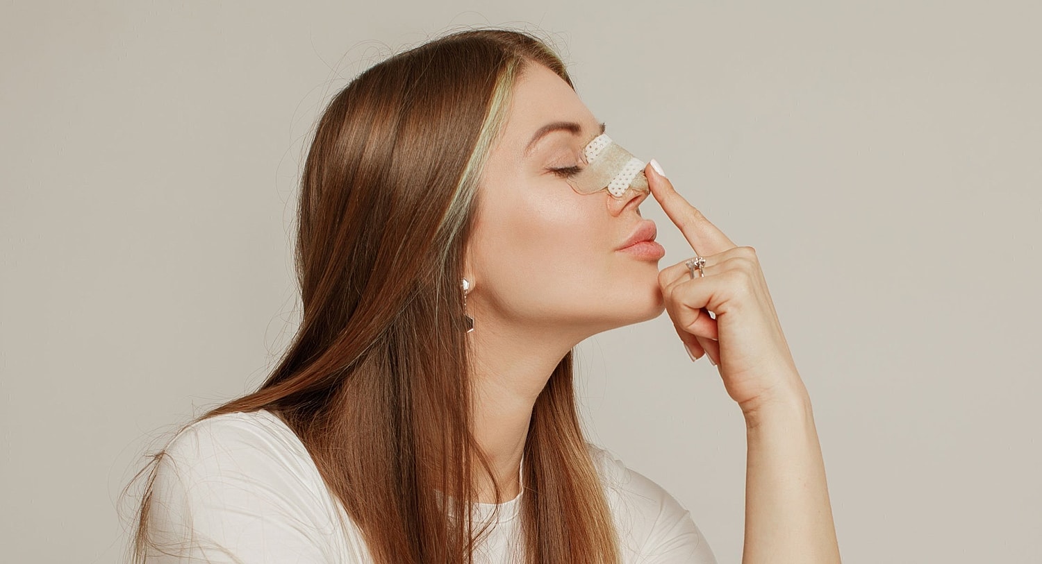 rhinoplasty patient model touching her nose after rhinoplasty surgery in orlando