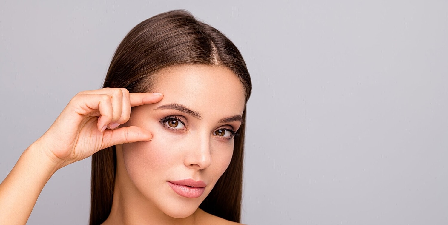 brow lift surgery patient model running her finger over her brow