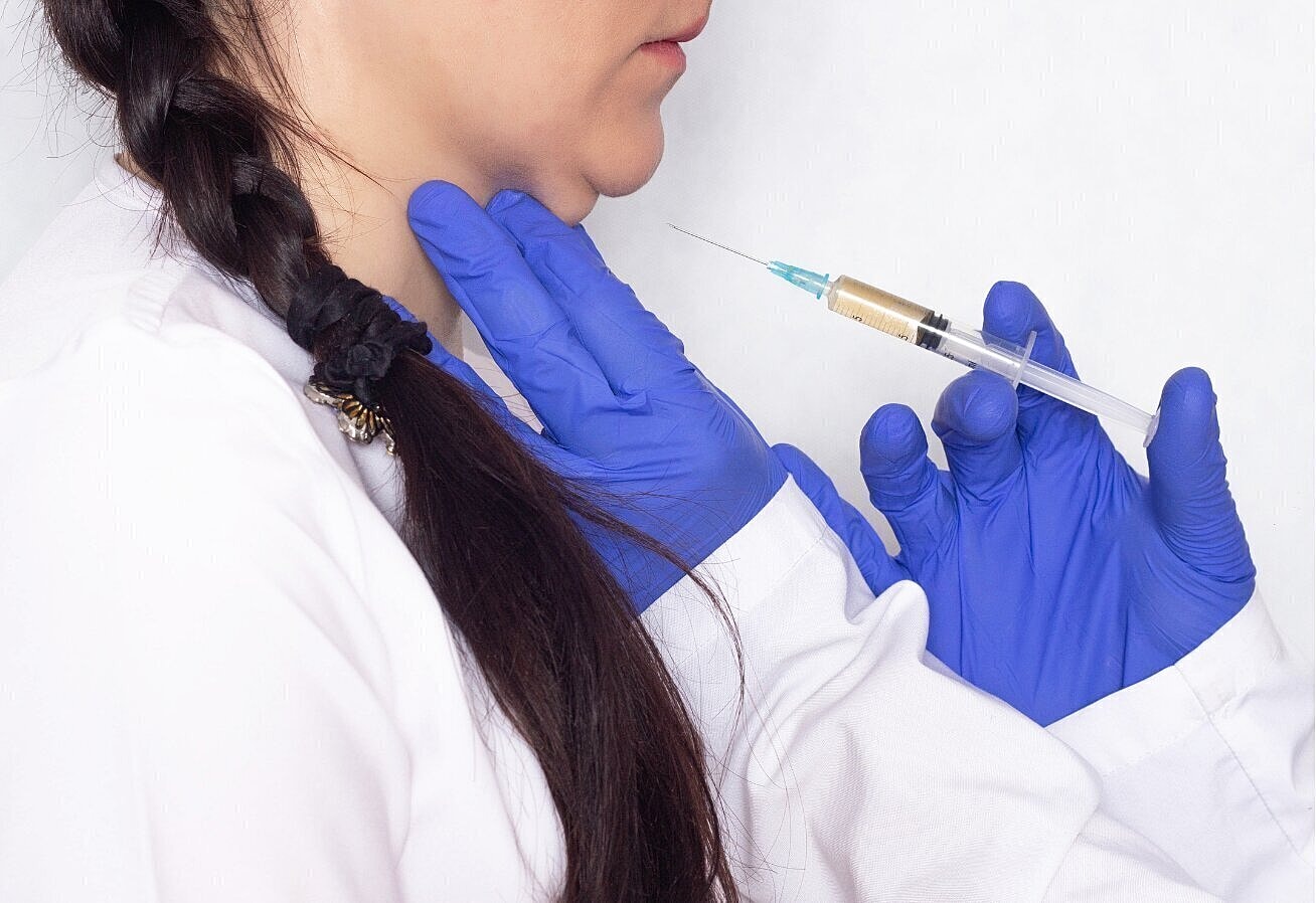 Kybella patient model receiving an injection to her chin