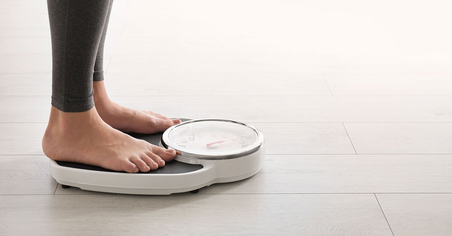 plastic surgery patient model standing on a scale