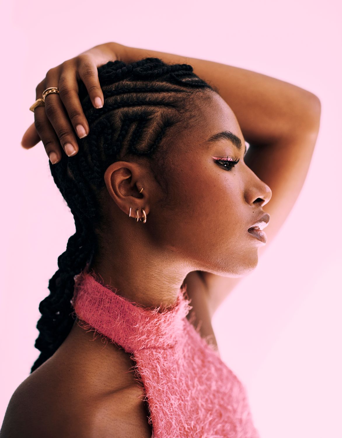 Profile of a woman with braided hairstyle and earrings.